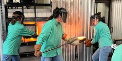three students in aqua lab coats work together in the hot shop