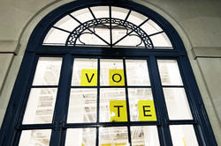 a sign inside a RISD window that spells out V-O-T-E