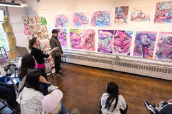 a student presents a series of pink, sparkly drawings inspired by magazine ads