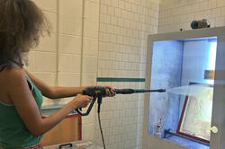 Zaila Strayhorn cleans screens with a hose