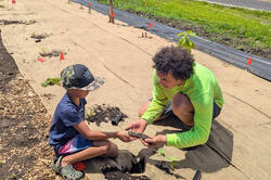 RISD student works with a young camper in Hawaii