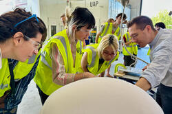 students in yellow safety vests visit an Urban Arts Project in progress