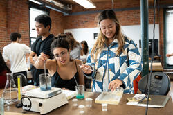 two students mix bioplastics on top of a hotplate