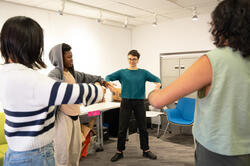 a student teaches ballet positions to the class