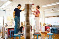 students work together on tall cardboard model