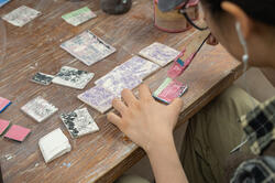a student brushes ceramic material onto clay