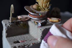 the artist at work on a tiny kitchen