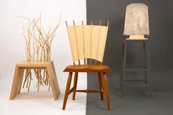 two sculptural wooden chairs and an end table stand left to right against a split white and dark gray background