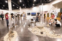viewers crouch down to engage with work at Grad Show 2026