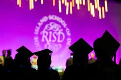 silhouette of grads in mortarboards against purple backdrop