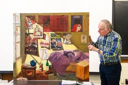 Professor Tom Roberts examines a student painting focused on propaganda