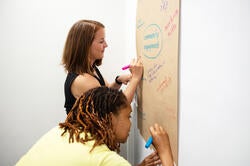 Teaching & Learning Lab workshop participants write ideas on a large piece of butcher's paper