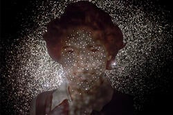 black-and-white image of a woman's face with tiny stars of light everywhere