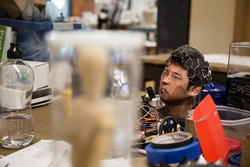 an Industrial Design student wears a wired device over his head