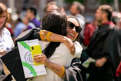happy grad hugging post-Commencement