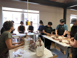 students working on clay around one table