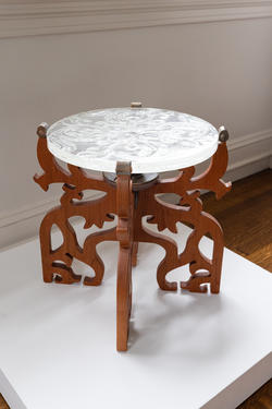 a short table with a wooden base and translucent, circular glass top