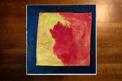 a painting of a perforated yellow and red square inside a solid blue painted border