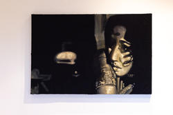 black-and-gold painting of a face emerging from heavy shadow