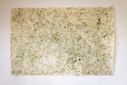 a rough-edged piece of off-white paper marked with irregular streaks of dark green