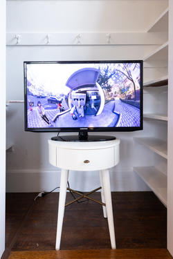 a television monitor sitting on a nightstand displays a distorted street image
