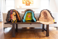 three irregularly shaped objects with hollow insides sitting on a table and decorated inside with various objects