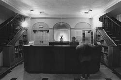 Black and white view of the circulation desk in the former library from RISD Archives.