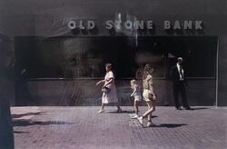View of pedestrians walking by Old Stone Bank in 1984 by Harry Callahan.