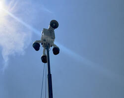 A mobile speaker/surveillance system against a blue sky.