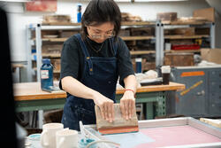 a student uses a squeegee on clay