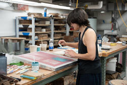A student puts ceramic ink on clay