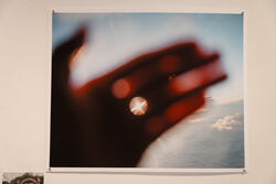 A photo of a blurry hand but you can see the sun through it