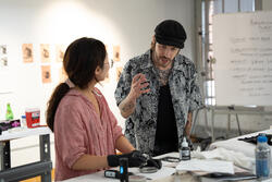 Tattoo artist and risd alum adam Krueger talks with a student