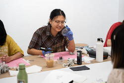 A student observes her work practicing tattooing