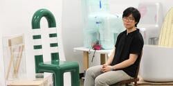 Joyce Line sits with a green chair that she designed