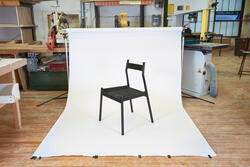 A black wooden chair on display for a photo shoot in a furniture shop