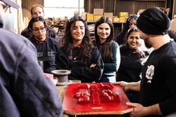 Students use a mold at a cast iron foundry
