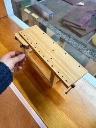 a hand touches a model tool bench