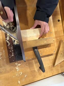 overhead view of hands shaping wood with a hand planer