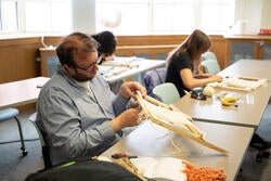 a student practices weaving on a loom