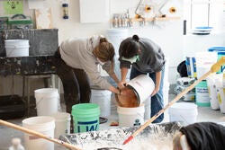 two students mix brick dust into lime putty