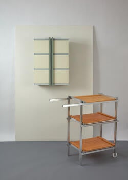 a wall-mounted white cabinet and a three-shelf cart made of light wood and metal