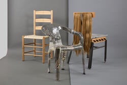 a left-to-right arrangement of a traditional wooden chair, a chair with ornate black-and-white patterns, and a mixed-media chair including hair on the back support
