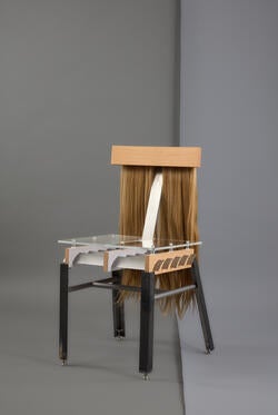 a mixed-media chair incorporating long synthetic hair into the chair back