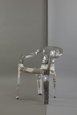 a fiberglass chair with asymmetrical white and black lines along its surfaces