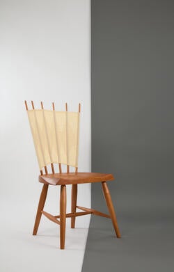 a traditional Windsor chair with cotton fabric integrated into the chair back