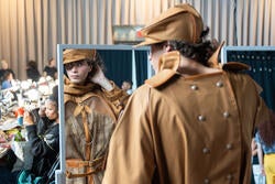 a model wearing work by Mariam Devadze views themselves in a backstage mirror