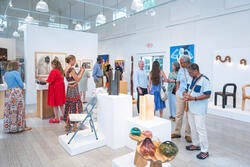 visitors examine work on view at the opening