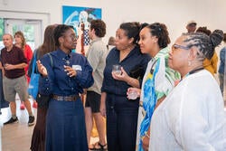 one of the artists discusses her work with visitors at the exhibition