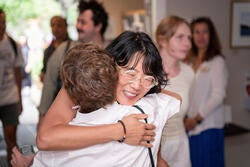one of the artists hugs a family member at the opening